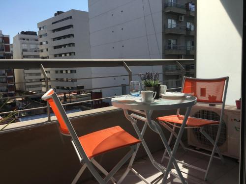 a small table and chairs on a balcony with a window at 629 Serrano in Buenos Aires