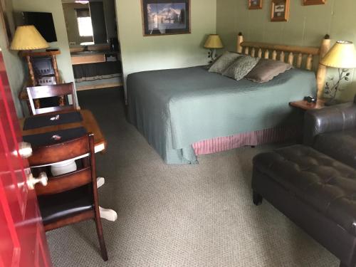 a bedroom with a bed and a chair and a couch at Mingo Motel in Wallowa