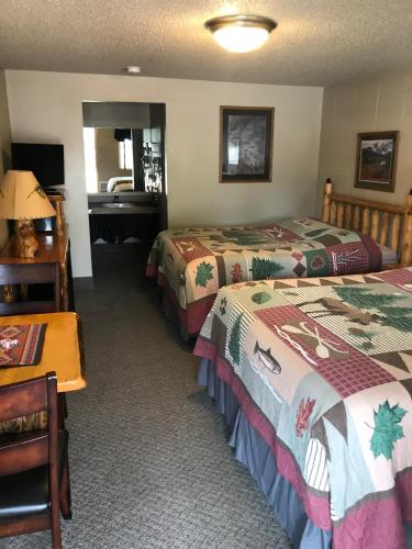 a hotel room with two beds and a desk at Mingo Motel in Wallowa