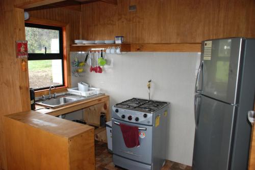 a kitchen with a stove and a stainless steel refrigerator at Don Zoilo in Castro