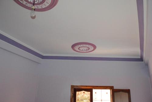 a room with a ceiling with purple trim at Auberge Restaurant Rooftop Tamazirt in Boumalne