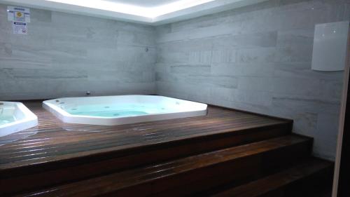 a bath tub in a bathroom with a wooden floor at Le Bon Vivant in Arraial do Cabo