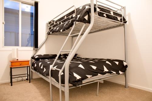 a triple bunk bed in a room with a window at Sapphire Cottage in Glen Innes