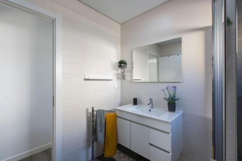 a white bathroom with a sink and a mirror at Maria Rita Faro Rooftop Apartment in Faro