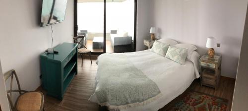 a bedroom with a large bed with a green dresser at Depto. orilla de lago Villarrica in Pucón