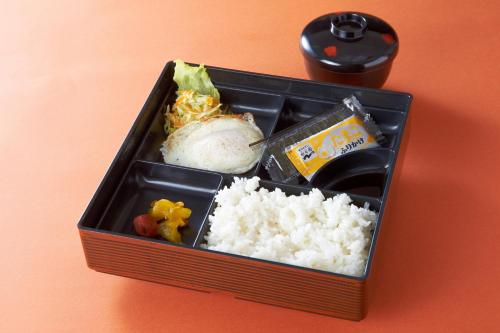 una caja de almuerzo con arroz y otros alimentos en Hotel Silk no Mori (Adult Only) en Tosu
