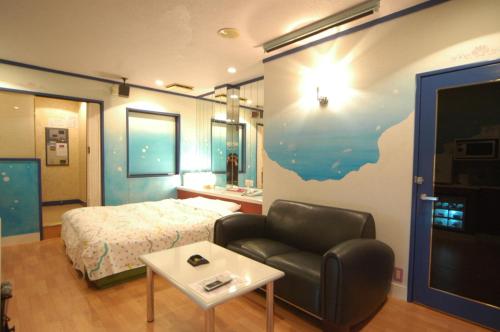 um quarto com uma cama, um sofá e uma mesa em Hotel Remy (Adult Hotel) em Tosu