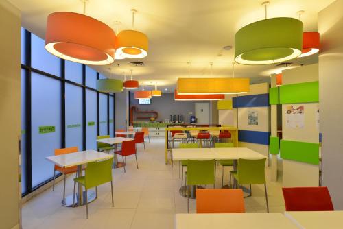 une cafétéria avec des tables, des chaises et des fenêtres dans l'établissement POP! Hotel BSD City Tangerang, à Serpong
