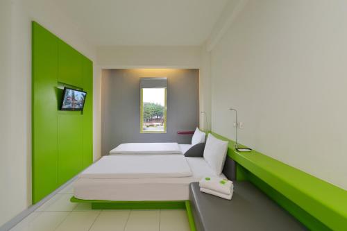 Tempat tidur dalam kamar di POP! Hotel BSD City Tangerang