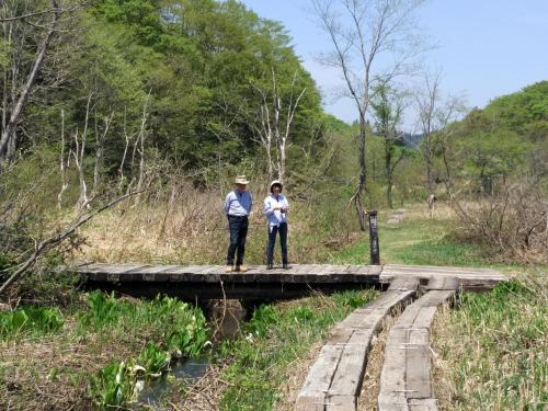 two people standing on a bridge over a river at Guest house Maroudo in Iiyama