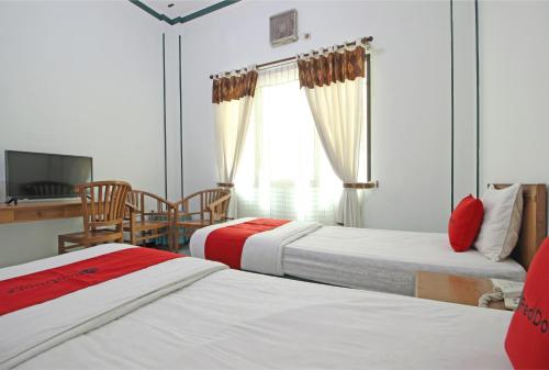 Tempat tidur dalam kamar di RedDoorz near XT Square Yogyakarta
