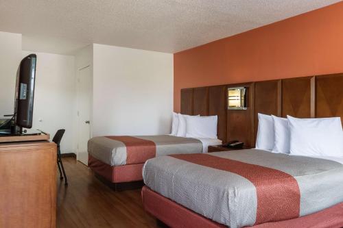 a hotel room with two beds and a flat screen tv at Motel 6-Van Buren, AR I- 40 in Van Buren