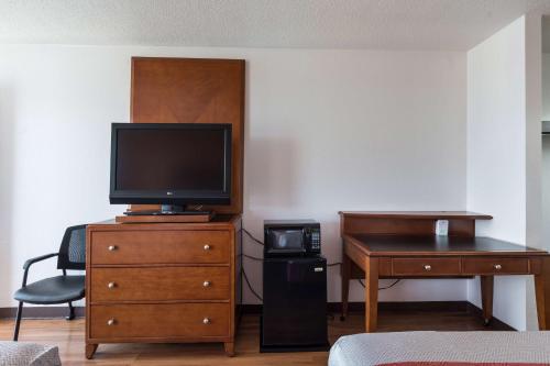 a room with a desk and a television on a dresser at Motel 6-Van Buren, AR I- 40 in Van Buren