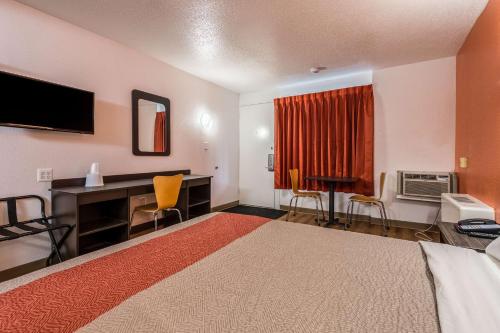 a hotel room with a bed and a desk and a television at Motel 6-Schenectady, NY in Schenectady