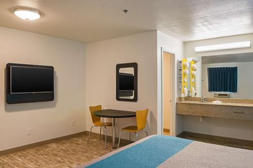 a room with a bed and a table and a sink at Motel 6-Bay Saint Louis, MS in Bay Saint Louis