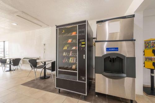 a large refrigerator in a room next to a table at Motel 6-Dayton, OH in Dayton