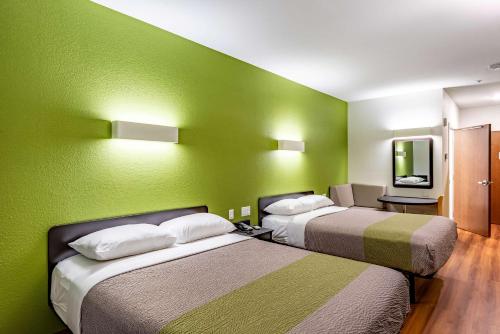 two beds in a room with green walls at Motel 6-Mankato, MN in Mankato