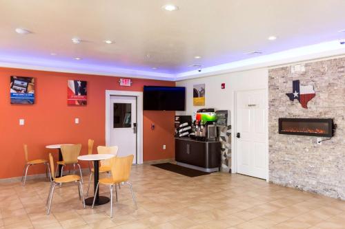 a dining room with a fireplace and a table and chairs at Motel 6-Houston, TX - North in Houston