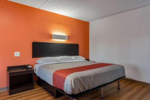 a bed in a room with an orange wall at Motel 6-White, GA - Cartersville in White