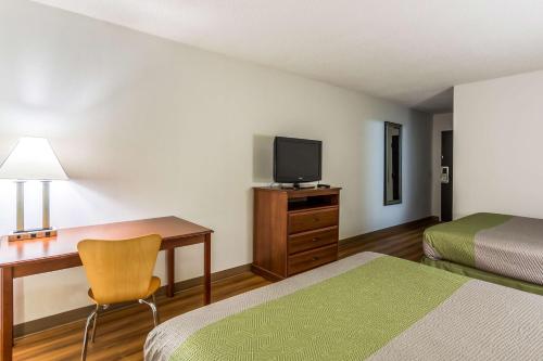 a hotel room with two beds and a desk with a television at Motel 6-Petersburg, VA - Fort Lee in Petersburg