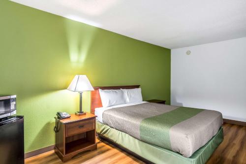 a bed in a room with a green wall at Motel 6-Petersburg, VA - Fort Lee in Petersburg