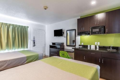 a small hotel room with two beds and a sink at Studio 6-Buttonwillow, CA in Buttonwillow