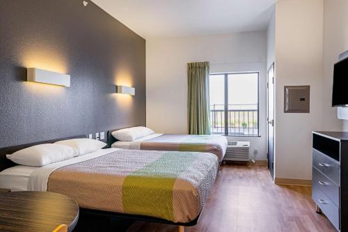 Una habitación de hotel con dos camas y una ventana. en Studio 6-Buda, TX, en Buda