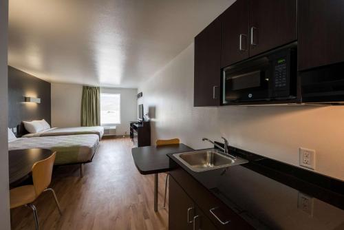 a hotel room with a bed and a kitchen with a sink at Studio 6-Mccarran, NV - Sparks - Tahoe - Reno Industrial Center in Clark