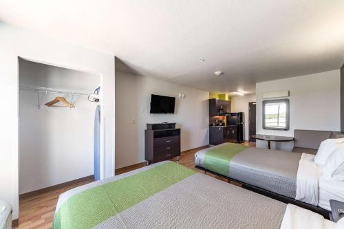 a hotel room with two beds and a kitchen at Studio 6-San Marcos, TX in San Marcos