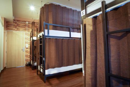 a room with two bunk beds and a curtain at Urban Hostel Bangkok in Bangkok