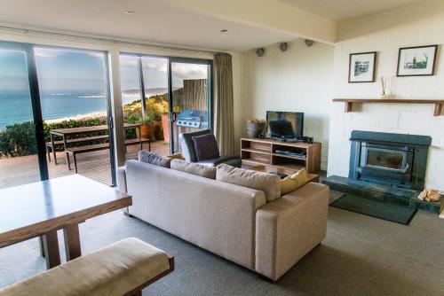 a living room with a couch and a fireplace at Beacon Point Ocean View Villas in Apollo Bay
