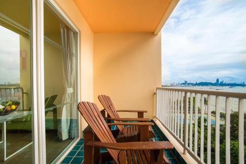 two chairs on a balcony with a view of the ocean at Best Bella Pattaya in Pattaya North