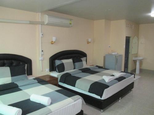 two beds in a hotel room withacers at Pineapple Guesthouse in Karon Beach