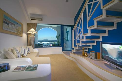 a living room with a white couch and a staircase at 真情非凡行館 Sealuv Homestay in Toucheng