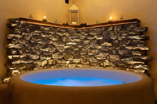 a bath tub in a room with a stone wall at La Maison D'Antan in Bionaz