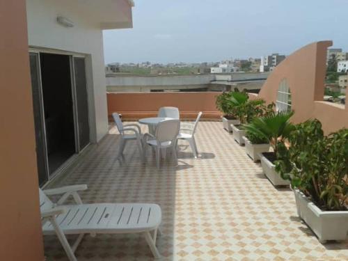 - Balcón con mesa y sillas en un edificio en Residence Les Calanques en Dakar