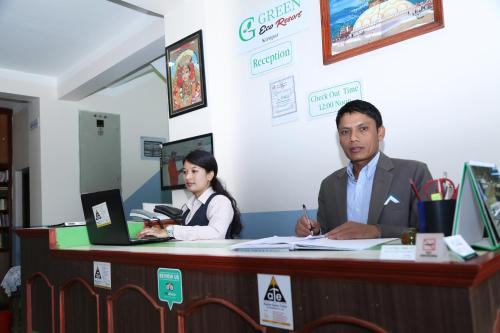 a man and a woman sitting at a desk with computers at Green Eco Resort in Kirtipur