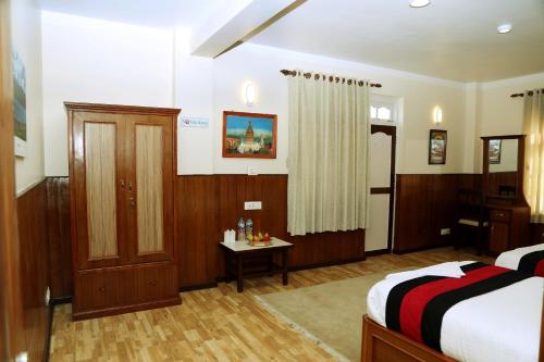 a bedroom with a bed and a table in it at Green Eco Resort in Kirtipur