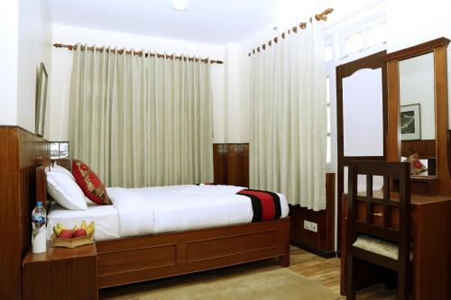 a bedroom with a bed and a mirror at Green Eco Resort in Kirtipur