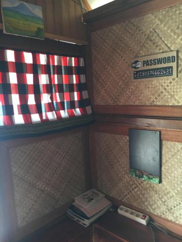 a room with a flag and a phone on a shelf at Eka's Bungalows in Maninjau