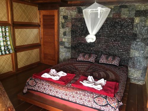 a bedroom with a bed with towels on it at Eka's Bungalows in Maninjau