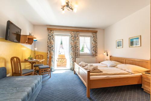 una camera con letto, scrivania e tavolo di Hotel - Pension Scheiblechner a Göstling an der Ybbs