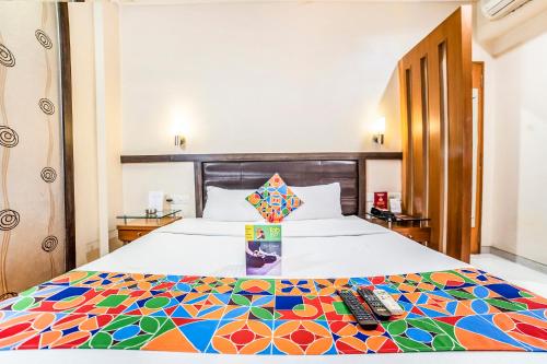 a hotel room with a bed with a colorful bedspread at Rapid Lakme Executive Hotel in Pune