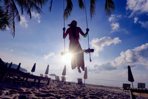 a person on a swing on the beach at Wyndham Grand Phu Quoc in Phu Quoc