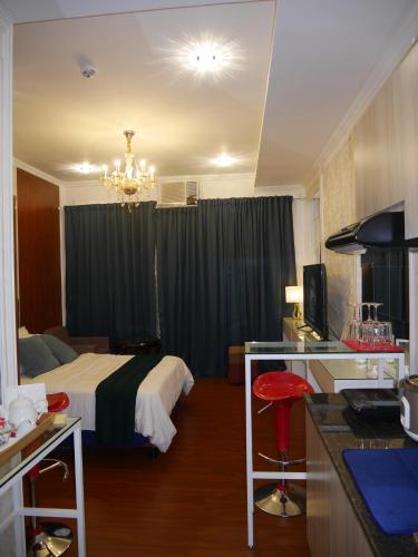 a hotel room with a bed and a kitchen with a counter at Trillium Residences Ayala Cebu in Cebu City