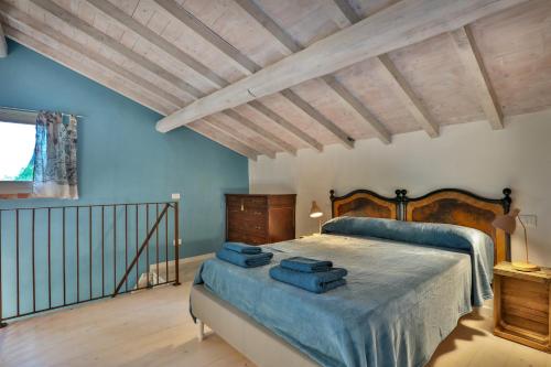 Un dormitorio con una cama con paredes azules y techos de madera. en Bacialupo Foresteria, en Montecalvo Versiggia