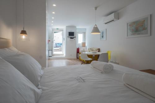 リスボンにあるCastle Terrace Exclusive Apartment - Home By The Castle Apartmentのテーブル付きの部屋の白いベッド1台