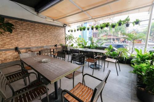 un patio con mesas y sillas y una pared de ladrillo en Hotel 88 Mangga Besar 62 Lokasari By WH en Yakarta