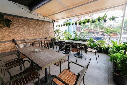 a patio with tables and chairs and a brick wall at Hotel 88 Mangga Besar 62 Lokasari By WH in Jakarta