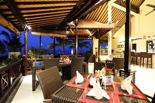een restaurant met een tafel en stoelen en uitzicht op de oceaan bij Teluk Karang Dive & Spa Resort in Tejakula